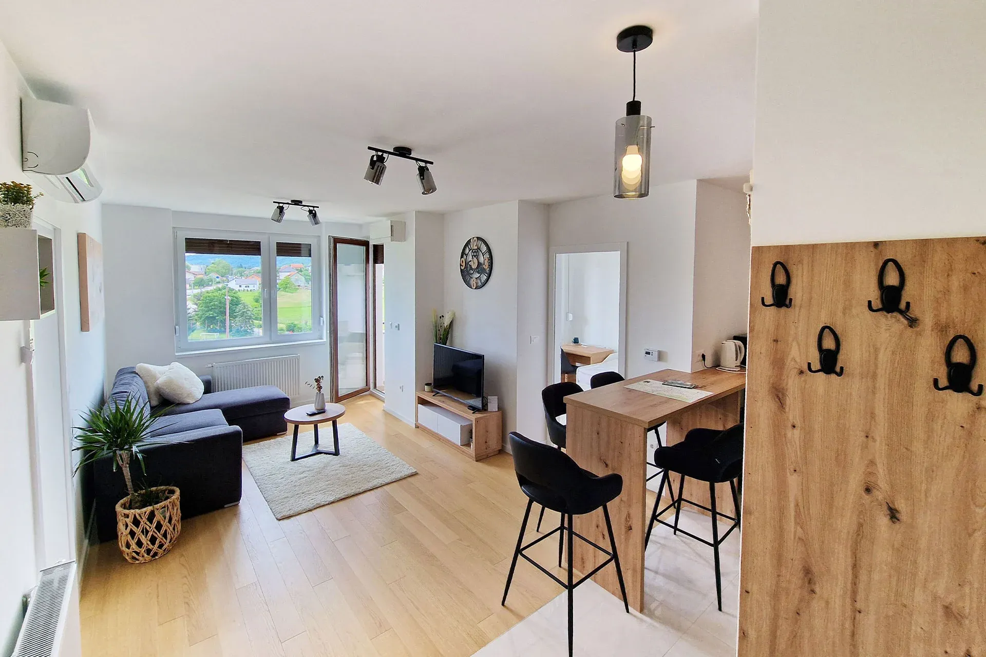 Queen Apartment Karlovac — sunlit living room with balcony view